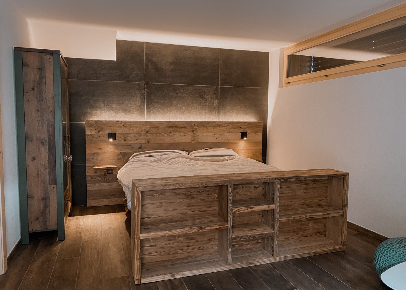 Le lit double et le mobilier en bois de la chambre